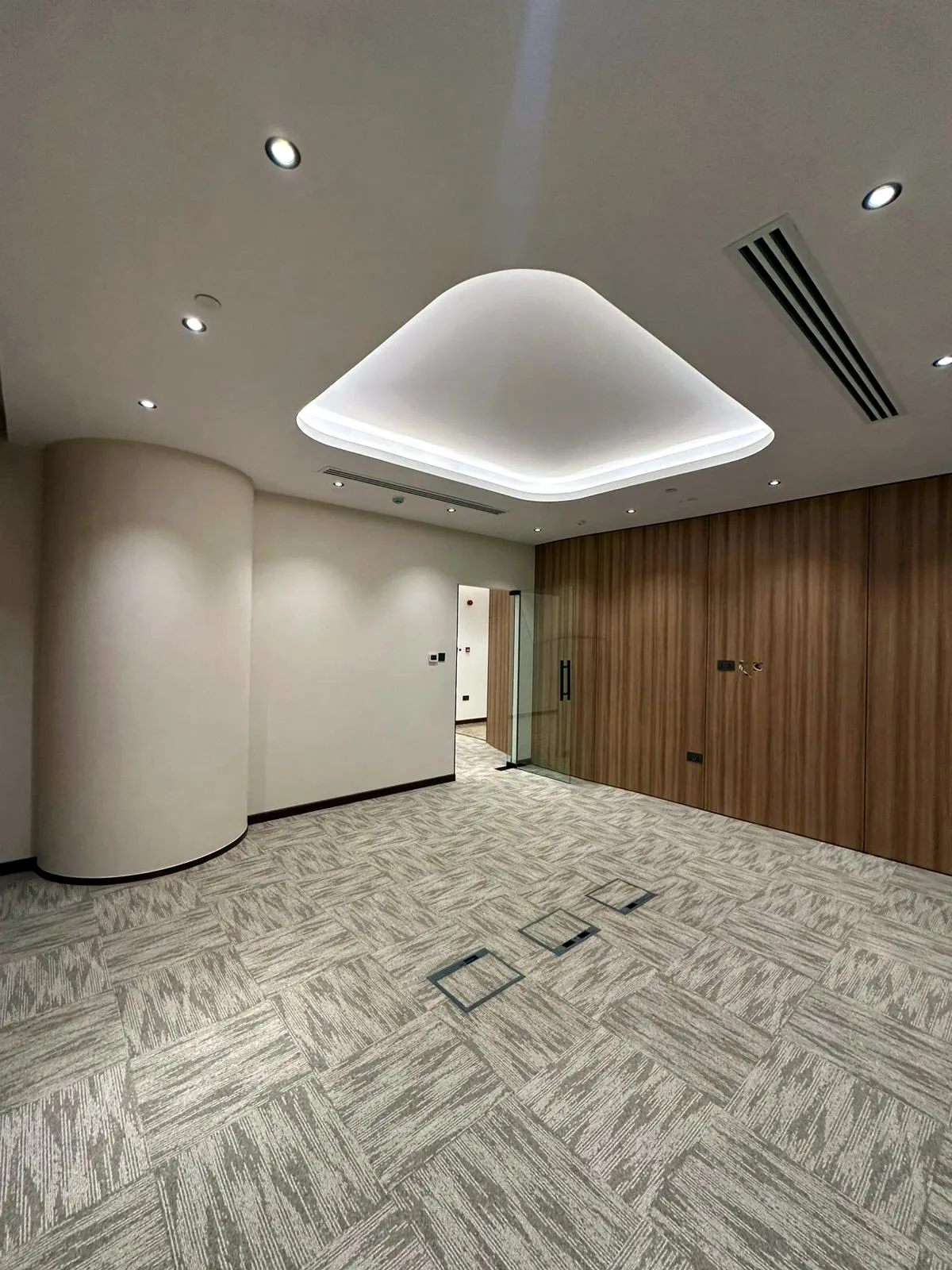 Finished office with a white feature ceiling cove, a curved wall and a timber wall panel.