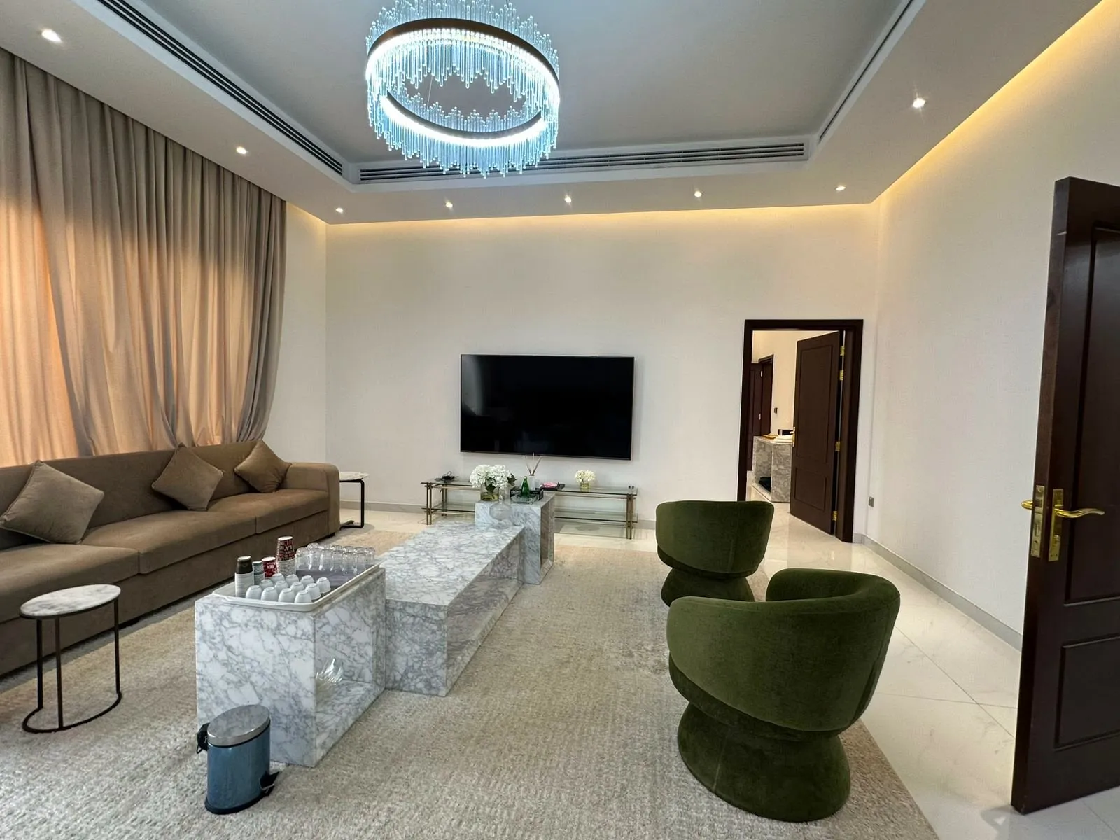 Adjacent lounge with chandelier, marble tables and velvet chairs