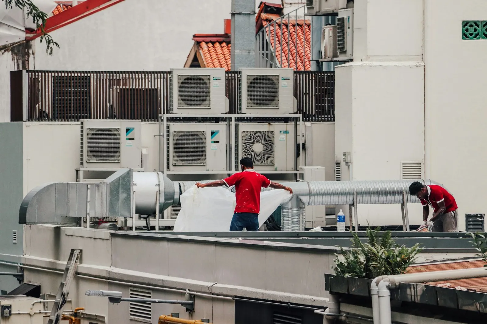 HVAC technicians working on rooftop cooling units