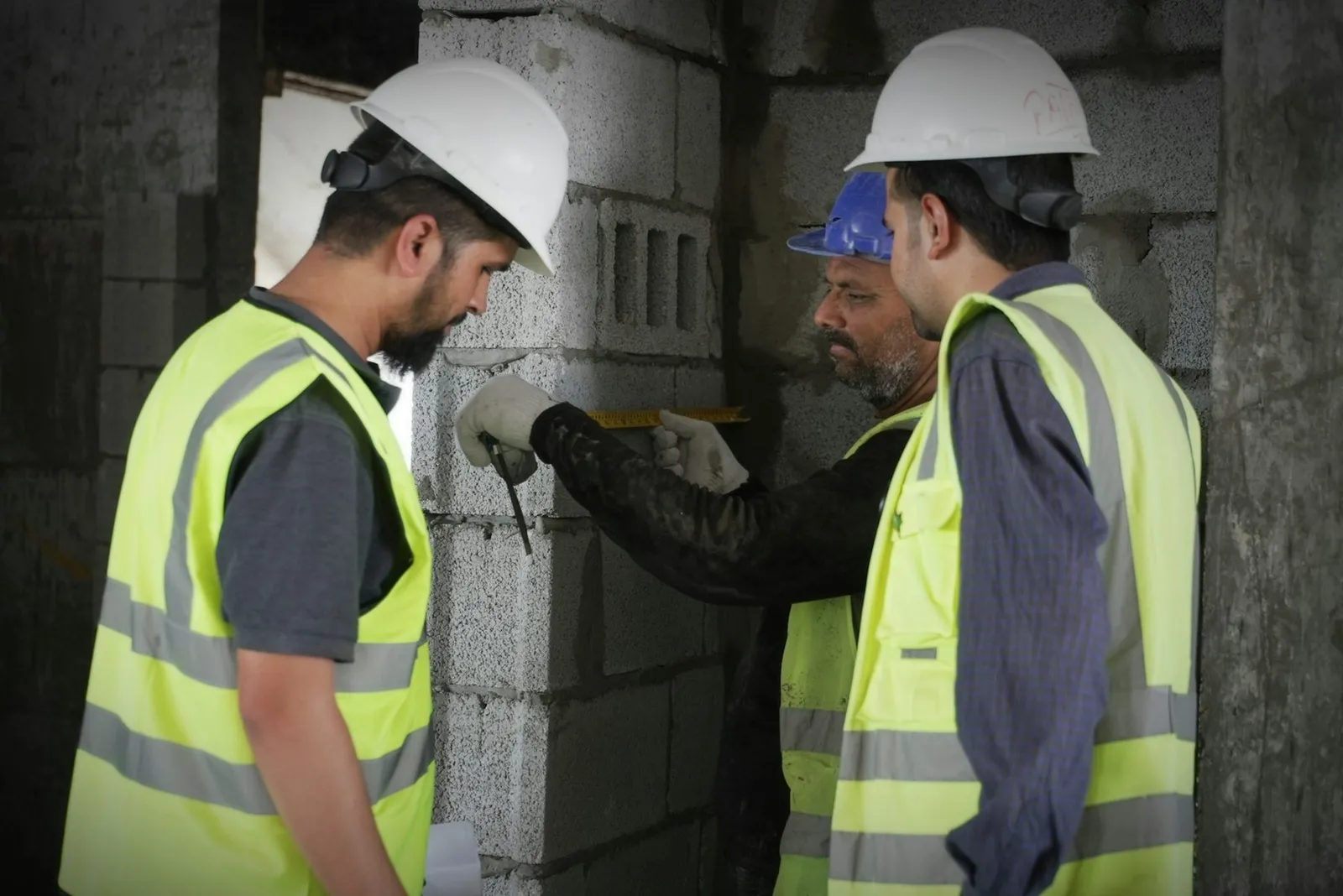 Workers measuring blockwork on a Dubai construction site